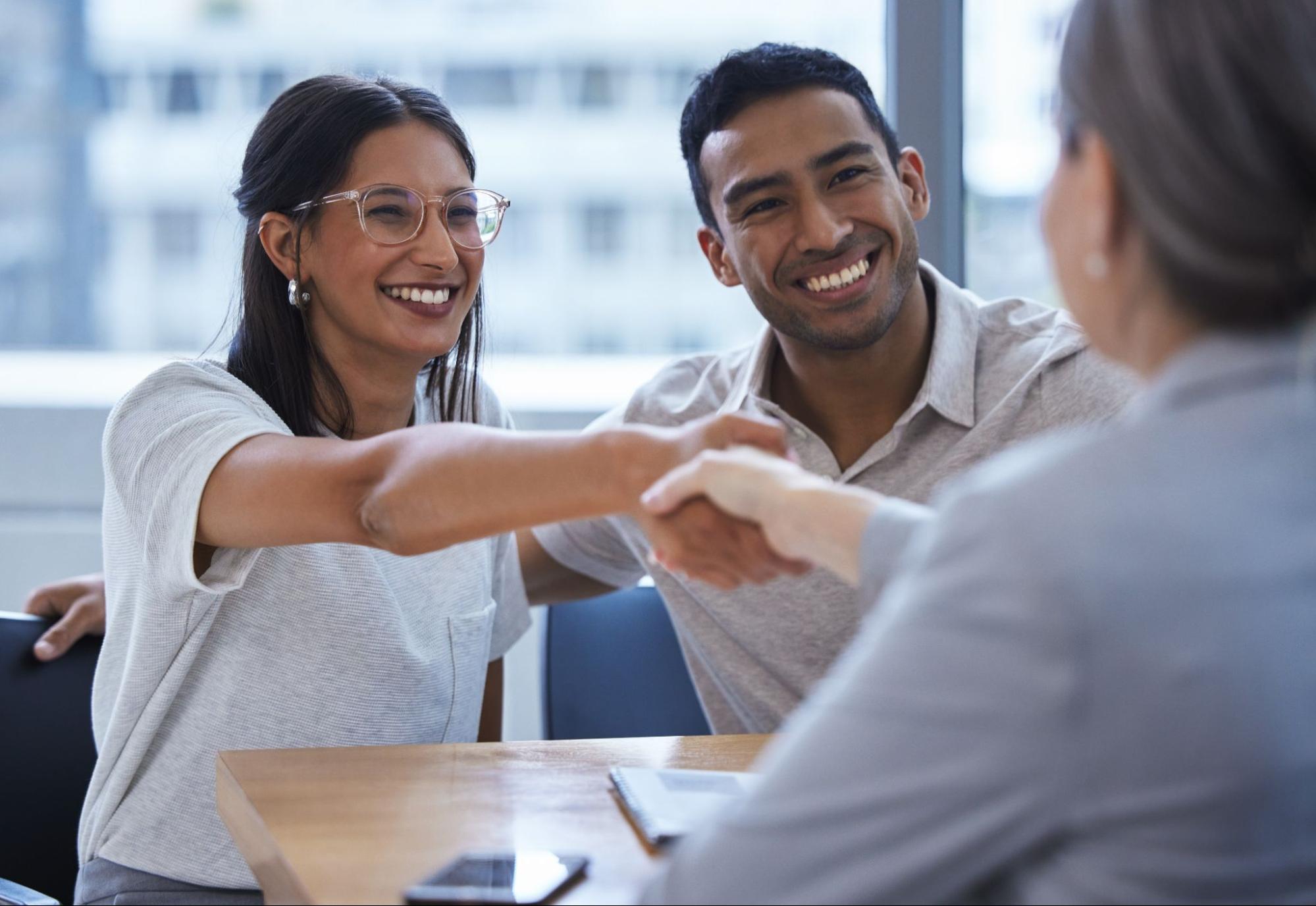 couple shaking hands with a man