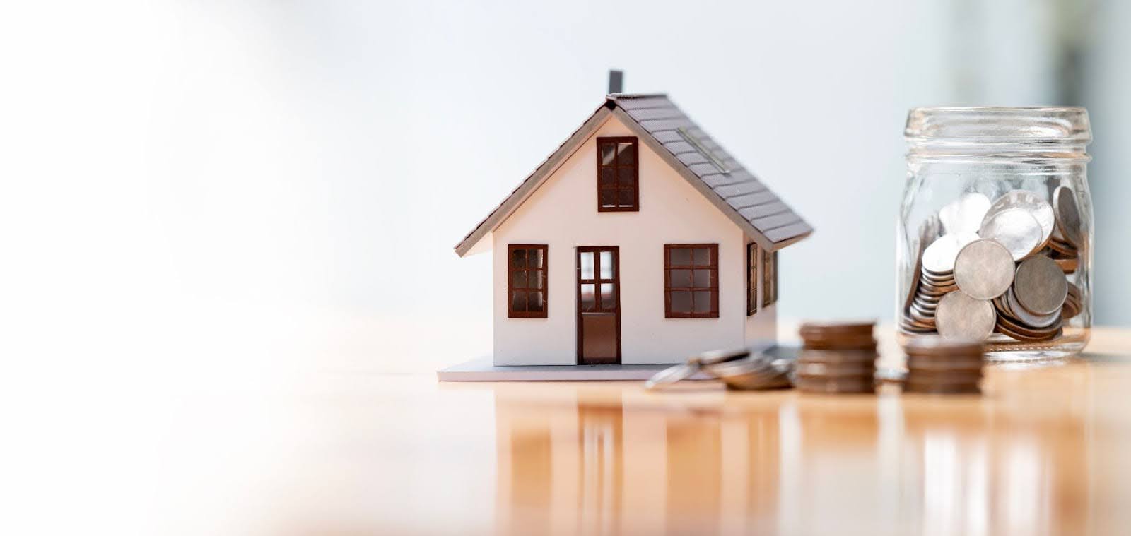 A home figurine beside a jar of change